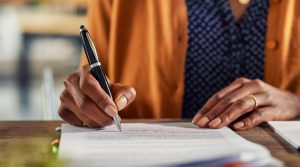 woman signing a document changing her last name after divorce