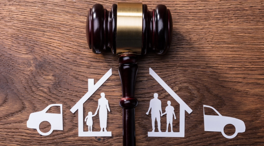 gavel dividing cutouts of house, family, and car